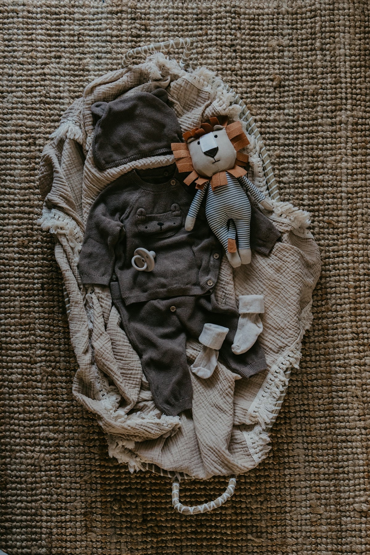 a stuffed animal laying on top of a pile of clothes