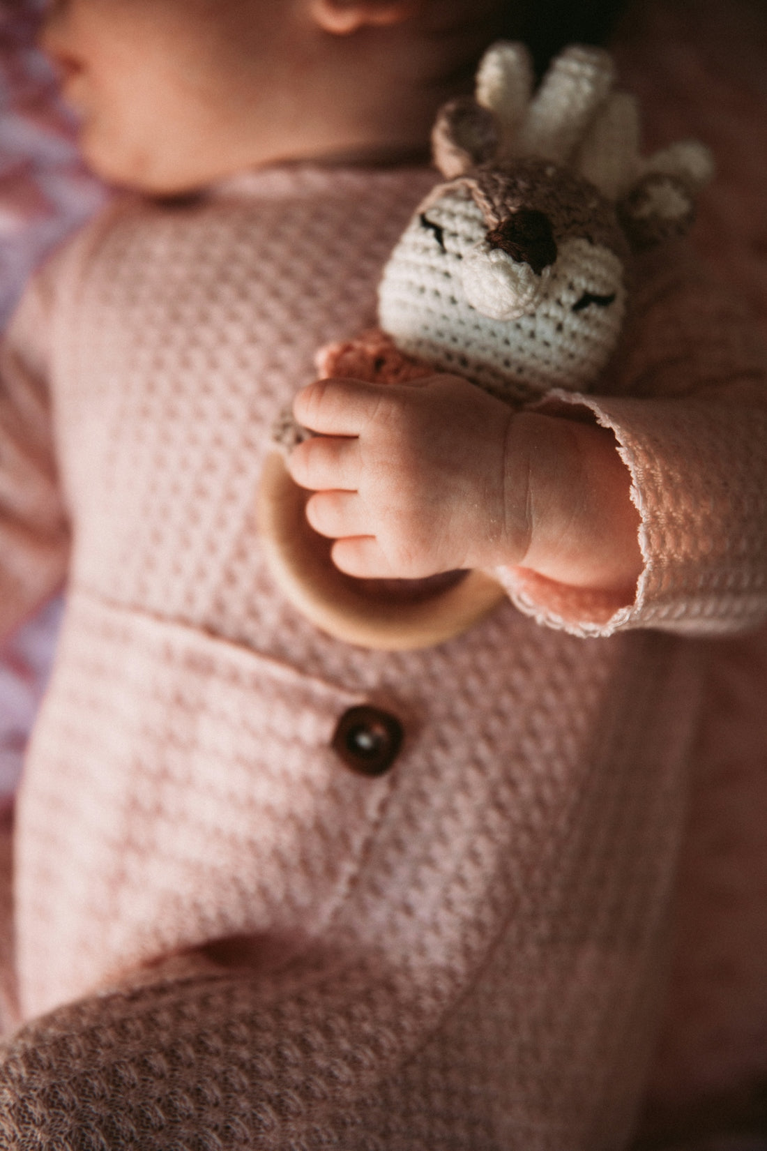 a baby is holding a stuffed animal in its hand