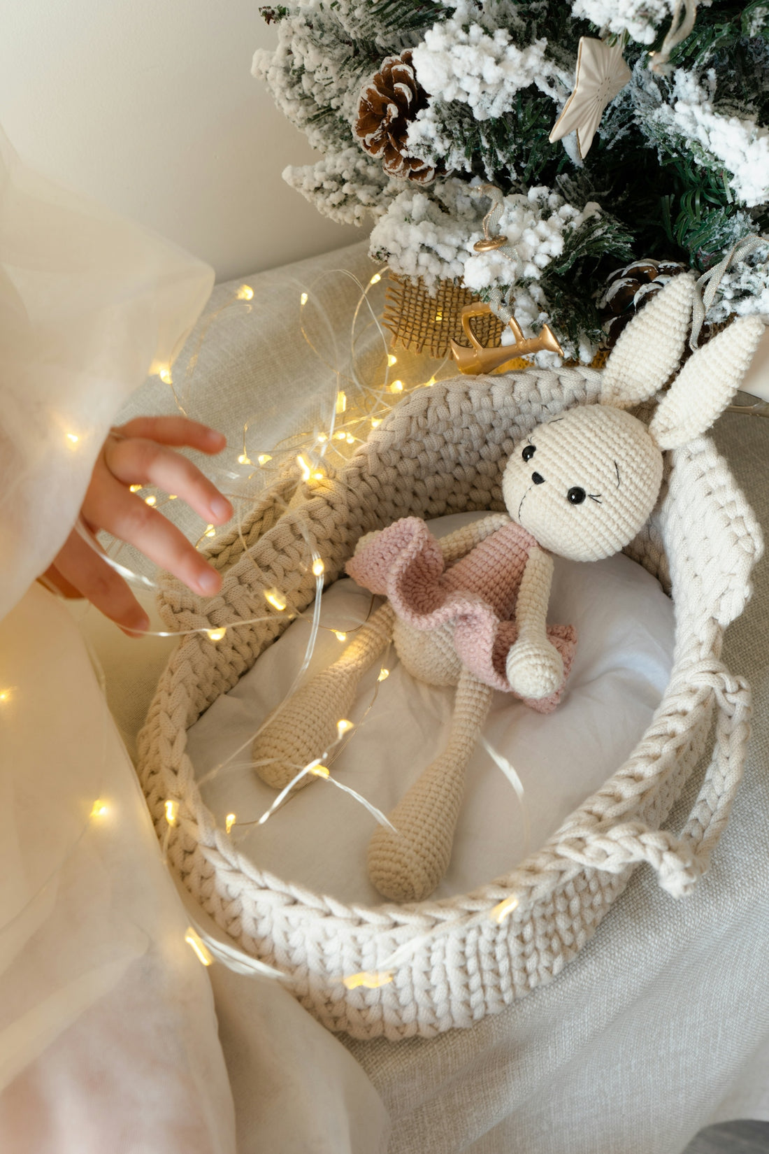 A stuffed animal in a basket next to a christmas tree