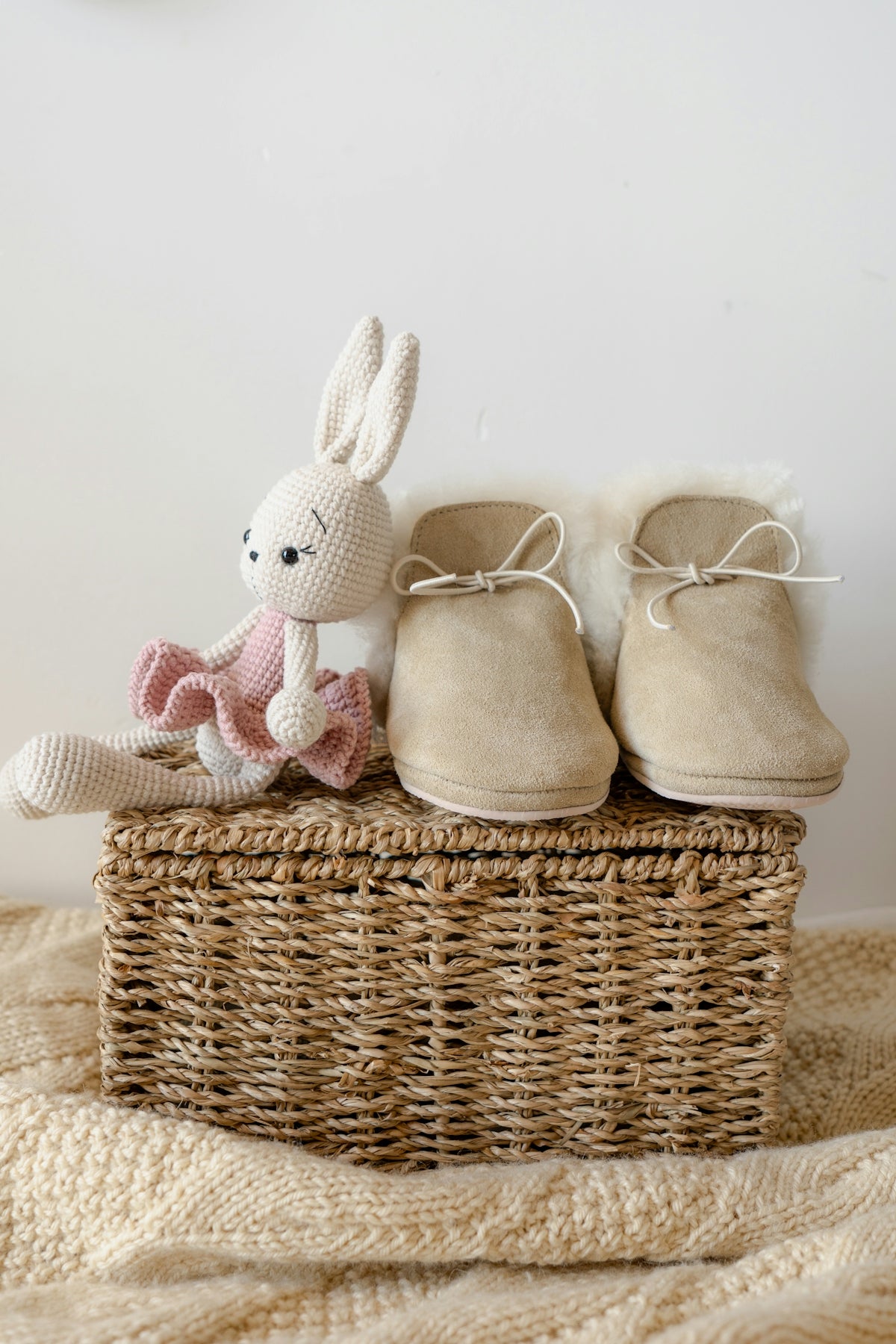A basket with a stuffed animal and a pair of shoes