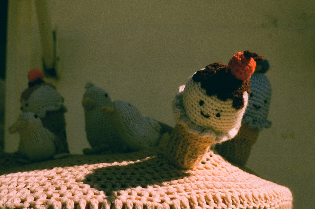 Crocheted ice cream cones with faces on display